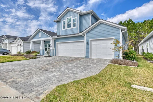 a view of a house with yard and large tree
