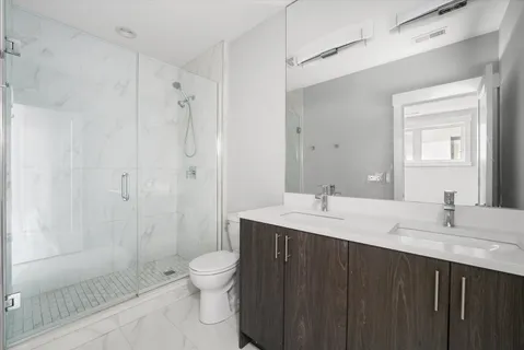 a bathroom with a granite countertop sink toilet a shower and a mirror
