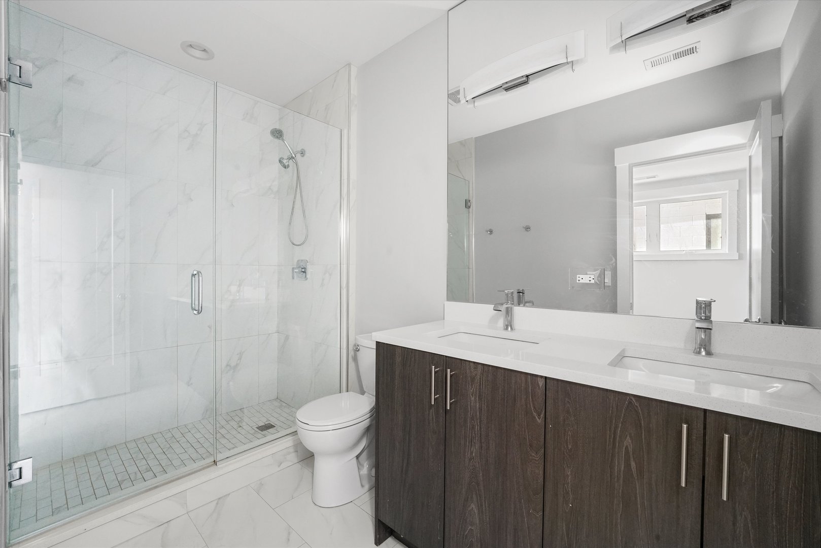 2529 West Congress Parkway, Unit 1 Chicago, IL 60612 - Photo 9 of 12 a bathroom with a granite countertop sink toilet a shower and a mirror