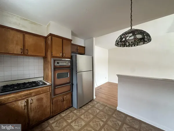a kitchen with stainless steel appliances a refrigerator and a stove top oven