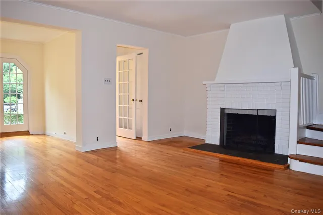 a view of empty room with wooden floor and fireplace