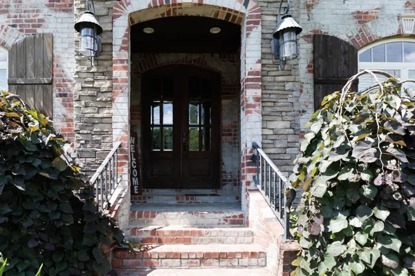an empty room with chandelier fan and windows