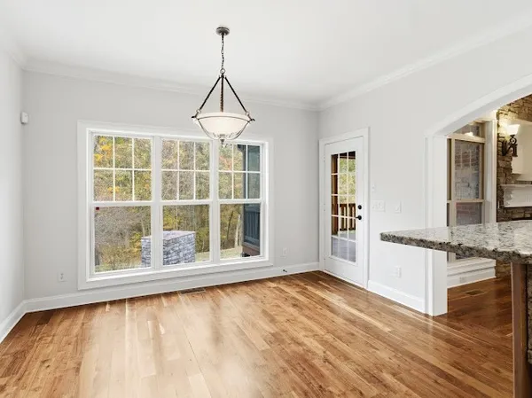 a bathroom with a granite countertop sink toilet a mirror and a window