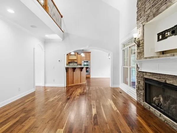 an empty room with ceiling fan and windows