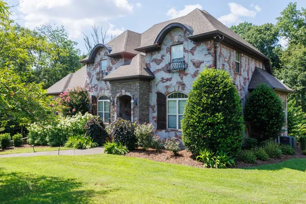 a front view of a house with a garden
