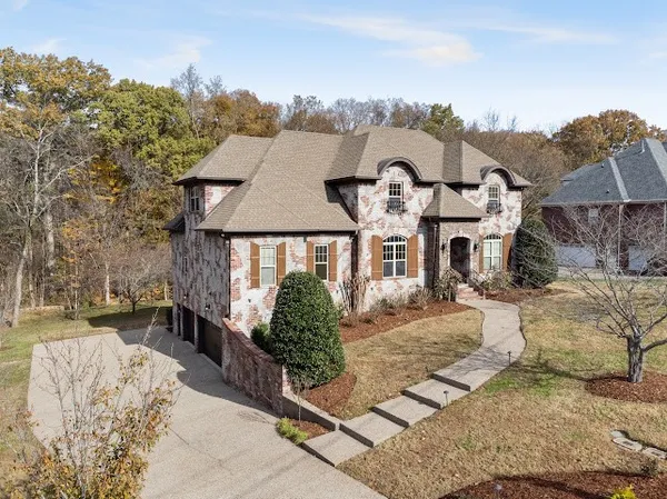 with aerial view of a house with swimming pool and large trees