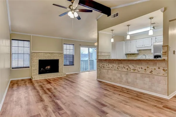 a view of an empty room with a fireplace and a window