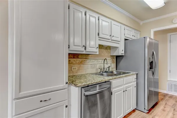 a kitchen with stainless steel appliances granite countertop a refrigerator sink and cabinets