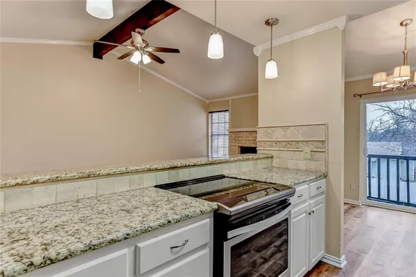 a kitchen with a stove and a wooden floor