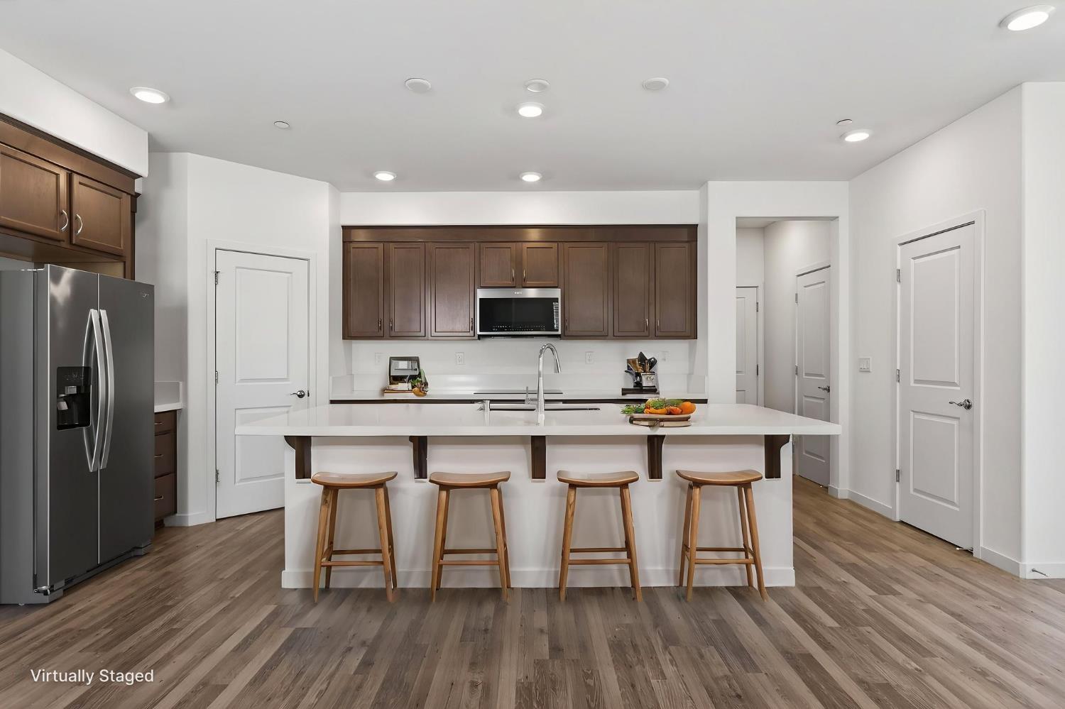 3080 Windwalker Walk Sacramento, CA 95833 - Photo 8 of 61 a kitchen with stainless steel appliances a microwave a stove a sink dishwasher a refrigerator and white cabinets with wooden floor