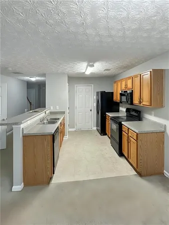 a large kitchen with stainless steel appliances granite countertop a stove a sink dishwasher and a refrigerator