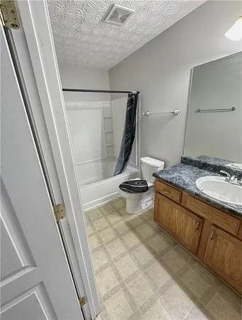 a bathroom with a granite countertop sink and a tub
