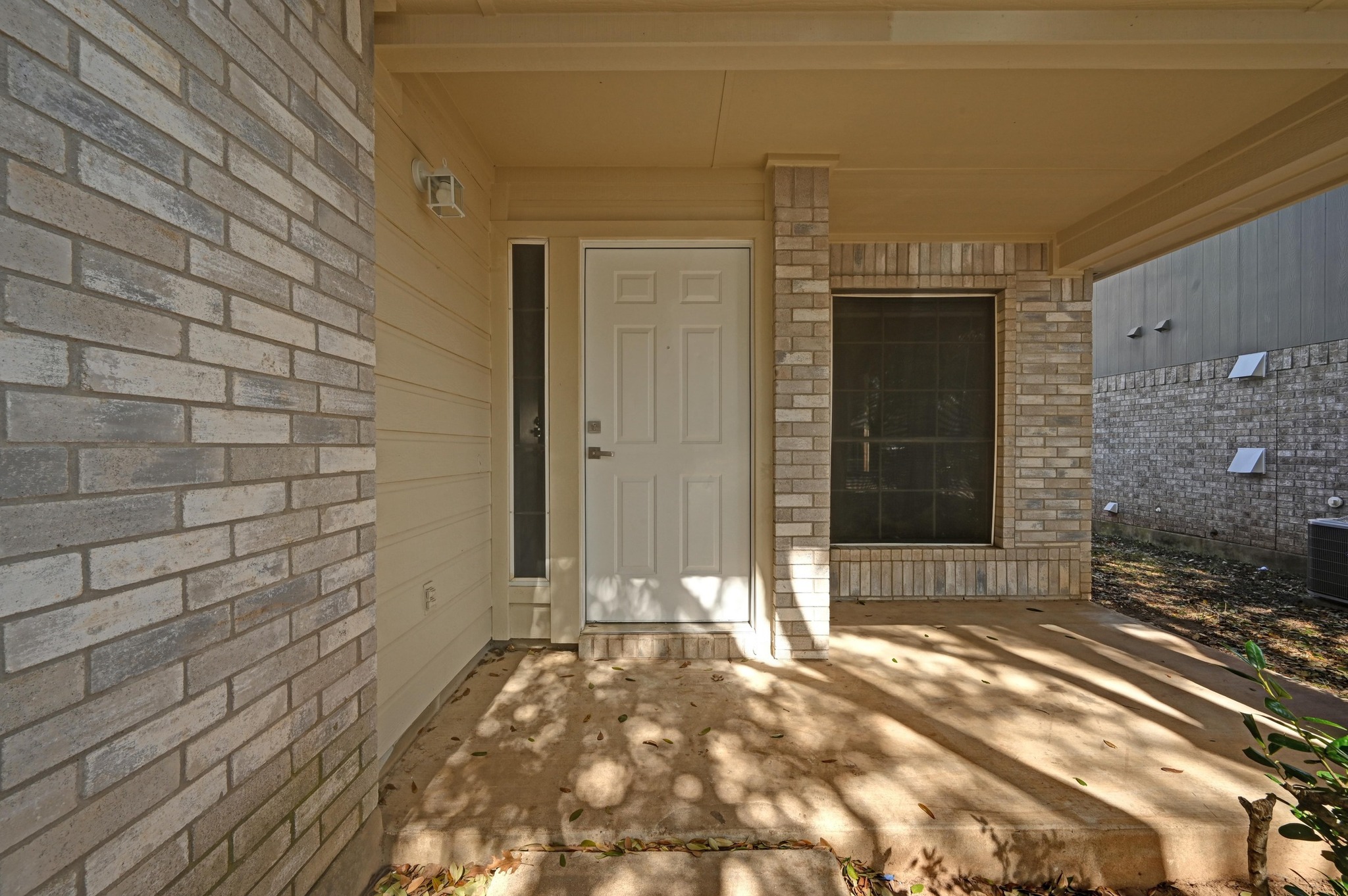 Property entrance with a patio area and brick siding