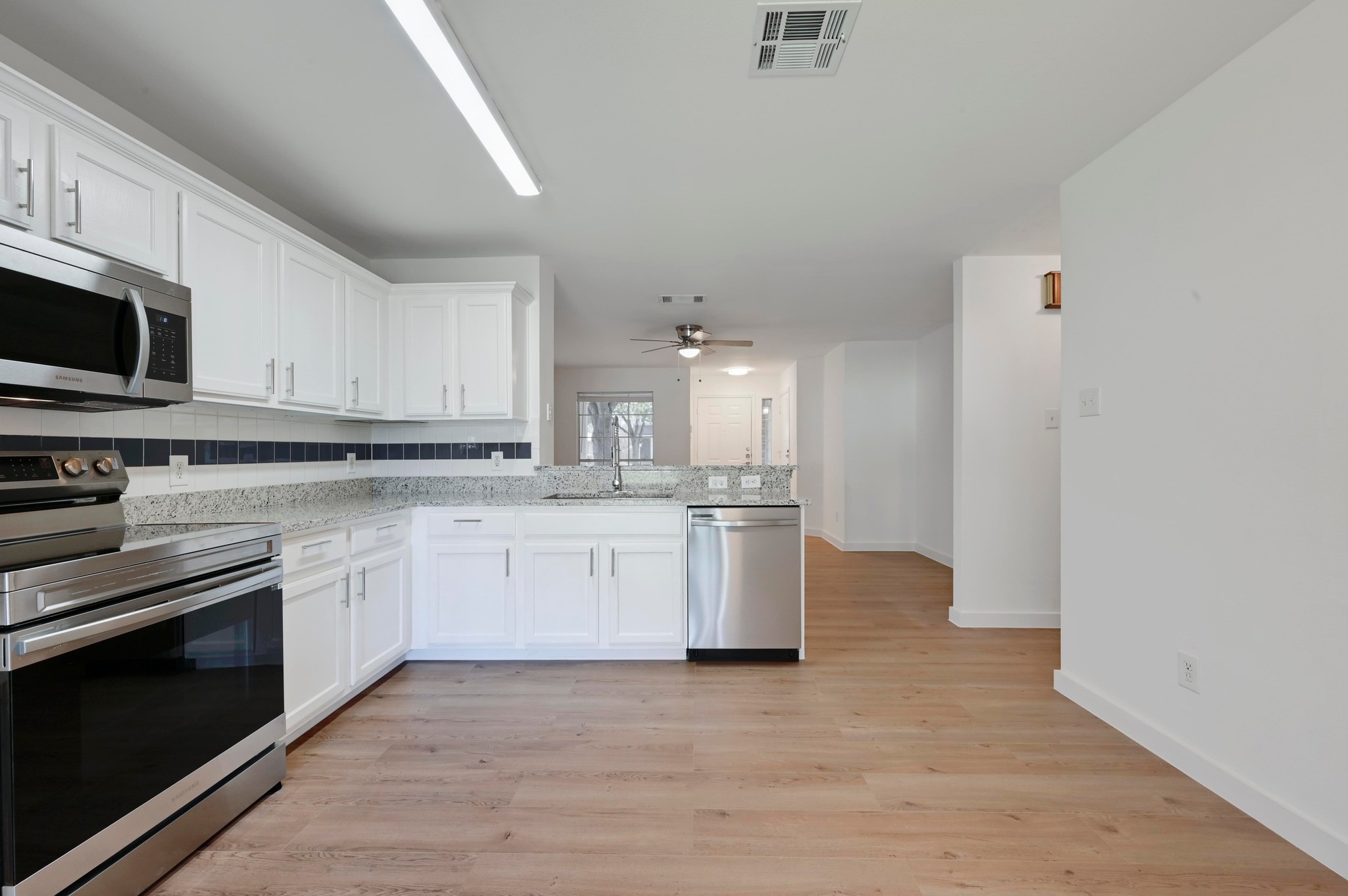 11106 Franklins Tale Loop Austin, TX 78748 - Photo 13 of 25 Kitchen with stainless steel appliances, white cabinetry, and light wood-style flooring