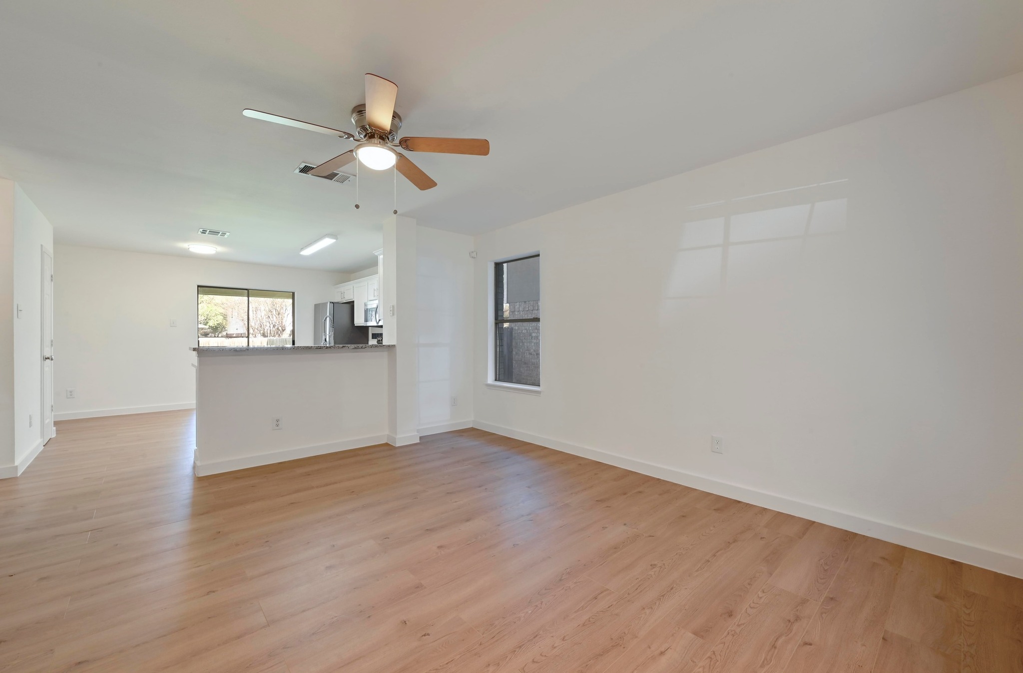 11106 Franklins Tale Loop Austin, TX 78748 - Photo 6 of 25 Unfurnished living room featuring light wood-style floors and a ceiling fan