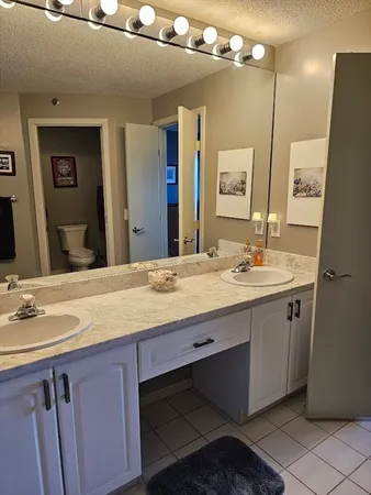 a bathroom with a granite countertop sink a large mirror and a shower