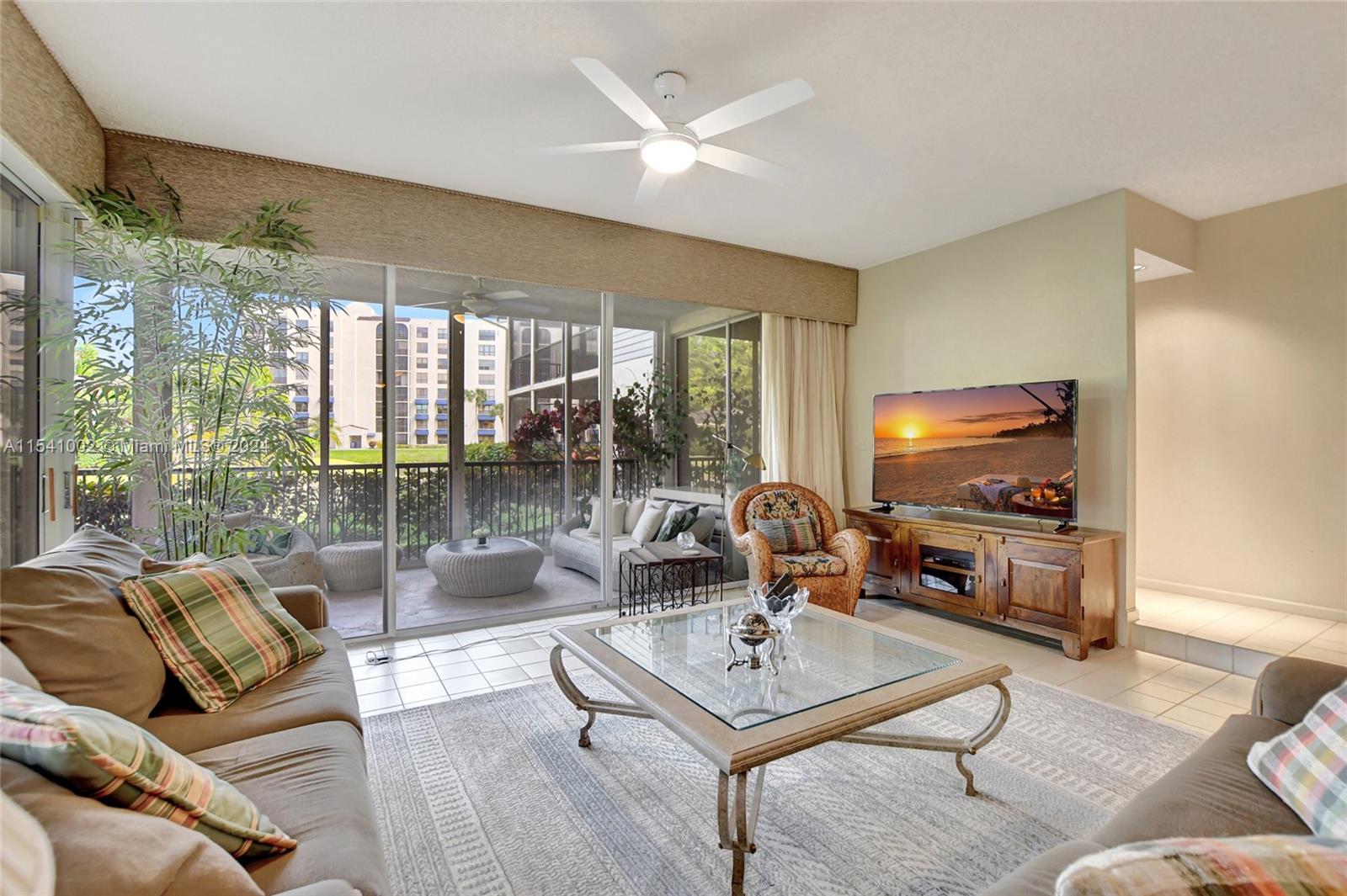 7602 Elm Ridge Drive, Unit 4L Boca Raton, FL 33433 - Photo 8 of 44 a living room with furniture a flat screen tv and a large window