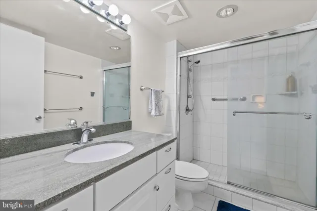 a bathroom with a granite countertop sink toilet and shower