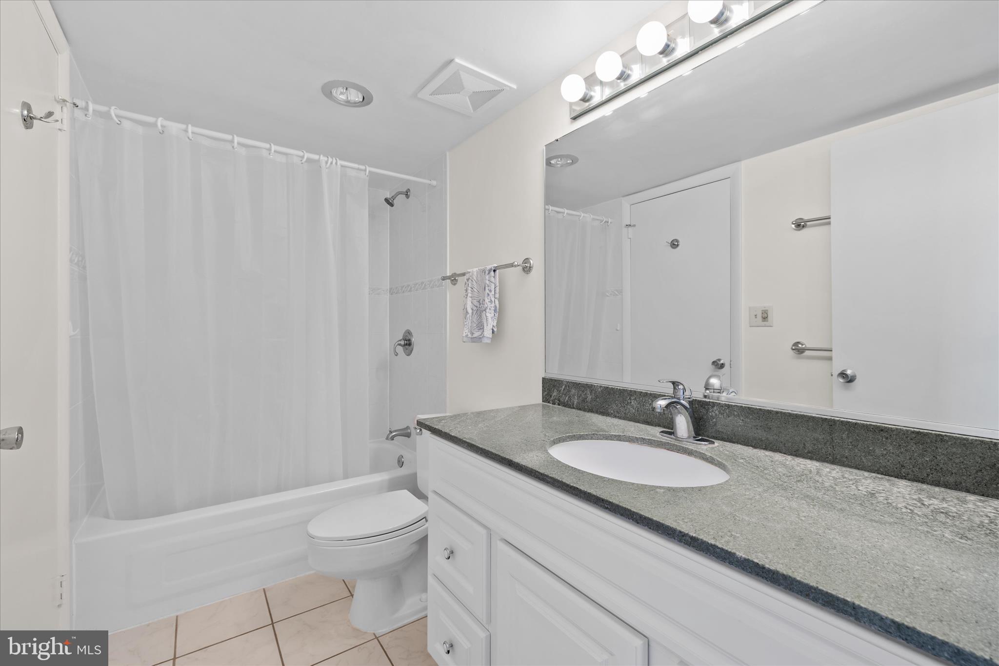 603 North Edgewater House Road, Unit 603N Bethany Beach, DE 19930 - Photo 20 of 40 a bathroom with a granite countertop sink a toilet a mirror and shower