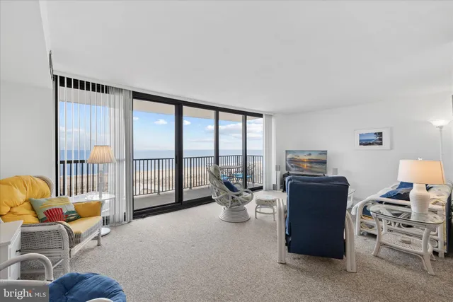 a living room with furniture a floor to ceiling window and a flat screen tv