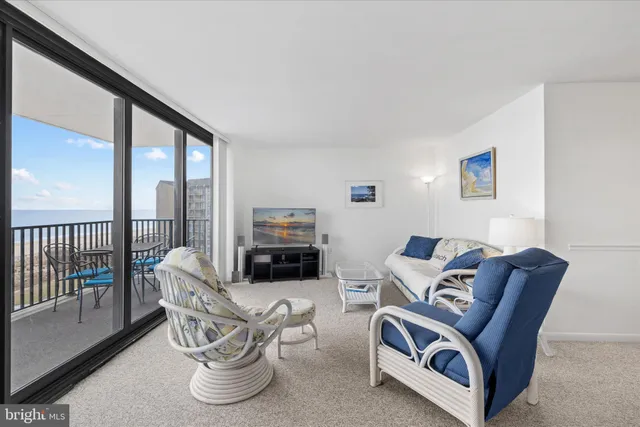 a living room with furniture a rug and a large window