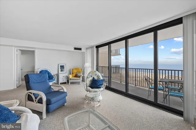 a living room with furniture and a floor to ceiling window