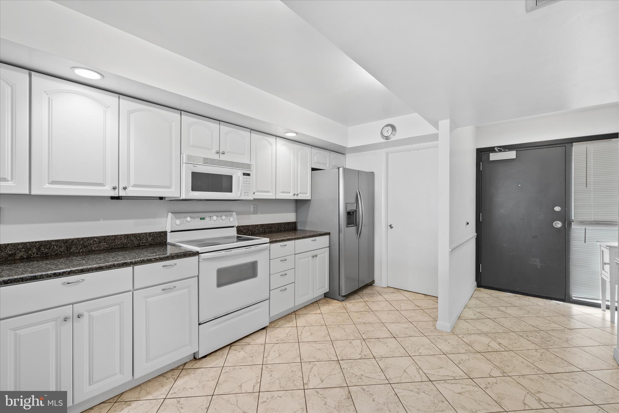 603 North Edgewater House Road, Unit 603N Bethany Beach, DE 19930 - Photo 9 of 40 a kitchen with white cabinets and white appliances
