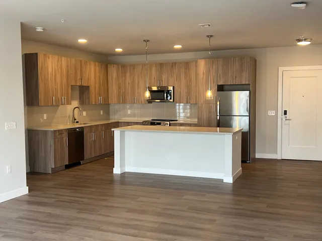 a kitchen with stainless steel appliances granite countertop a stove a sink and a refrigerator