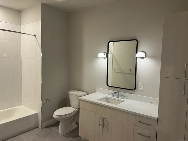 a bathroom with a toilet sink and mirror