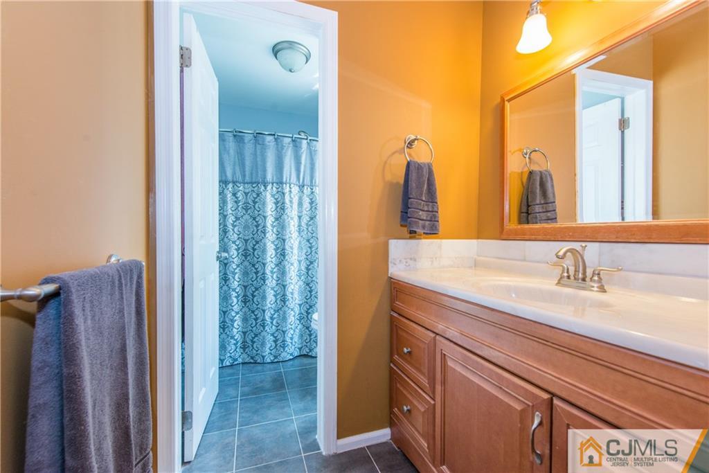 48 Roxy Avenue Edison, NJ 08820 - Photo 29 of 32 a bathroom with a granite countertop sink and a mirror