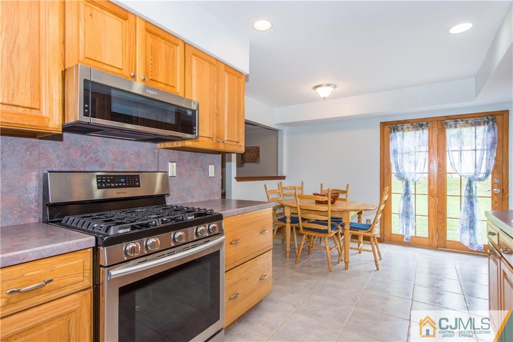 48 Roxy Avenue Edison, NJ 08820 - Photo 6 of 32 a kitchen with stainless steel appliances a stove a sink cabinets and a window