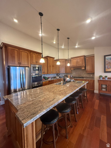 3145 South 500 West Vernal, UT 84078 - Photo 60 of 64 Kitchen with wood finish cabinets, a large island, dark stone counters, pendant lighting, and tasteful backsplash