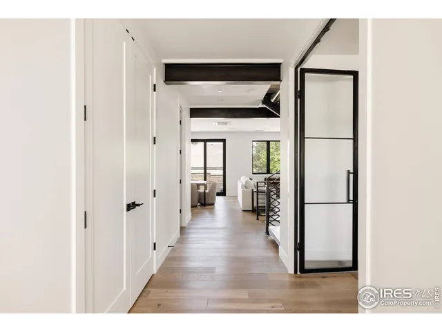 a view of a hallway with wooden floor and a living room