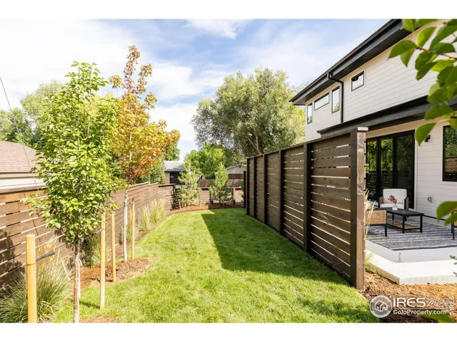 a view of a backyard with wooden fence