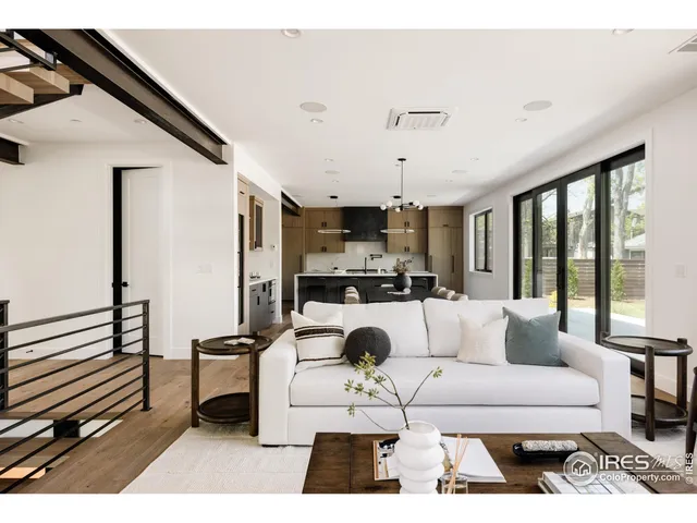 a living room with furniture a rug and white walls