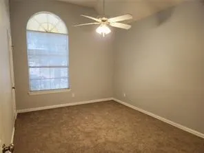 an empty room with a window and a fan