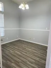 a view of a room with wooden floor and a window