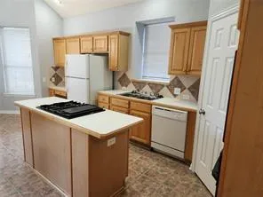 a kitchen with a stove a sink and a refrigerator