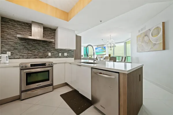 a room with stainless steel appliances kitchen island granite countertop a sink and cabinets