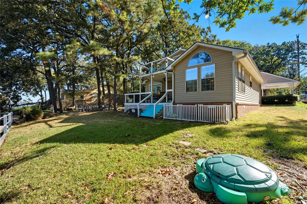 517 Shoreline Drive Tool, TX 75143 - Photo 23 of 28 a backyard of a house with table and chairs plants and large trees