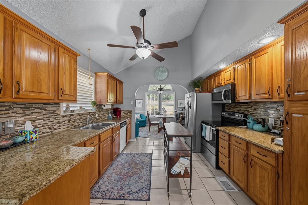 517 Shoreline Drive Tool, TX 75143 - Photo 6 of 28 a kitchen with stainless steel appliances granite countertop sink stove top oven and cabinets