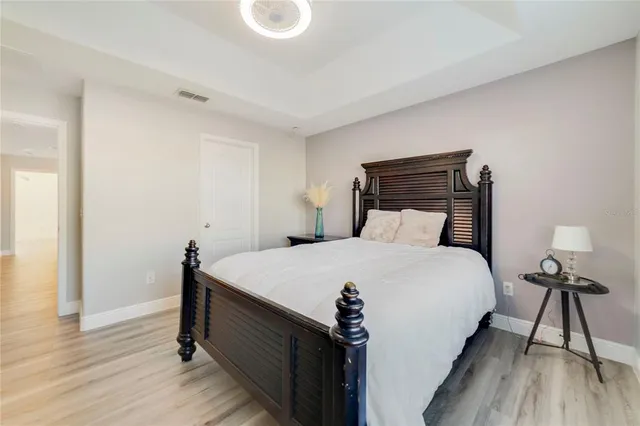 a bedroom with a bed and wooden floor