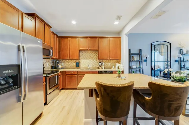 a large kitchen with a table chairs refrigerator and cabinets