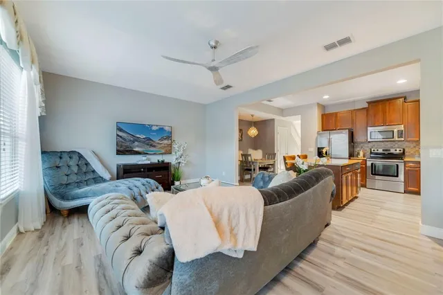 a living room with furniture kitchen and a wooden floor