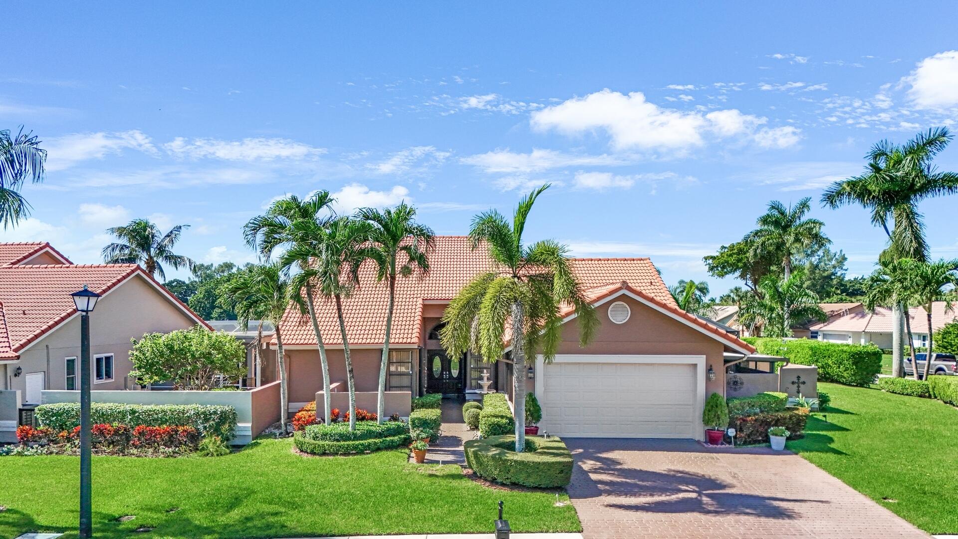19261 Cherry Hills Terrace Boca Raton, FL 33498 - Photo 1 of 53 a front view of a house with a garden and tree