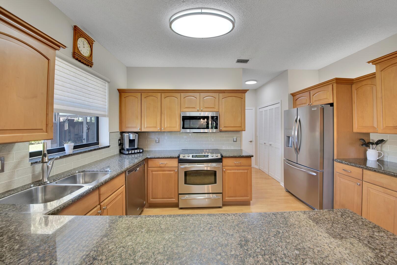 19261 Cherry Hills Terrace Boca Raton, FL 33498 - Photo 12 of 53 a kitchen with stainless steel appliances granite countertop a sink stove and refrigerator