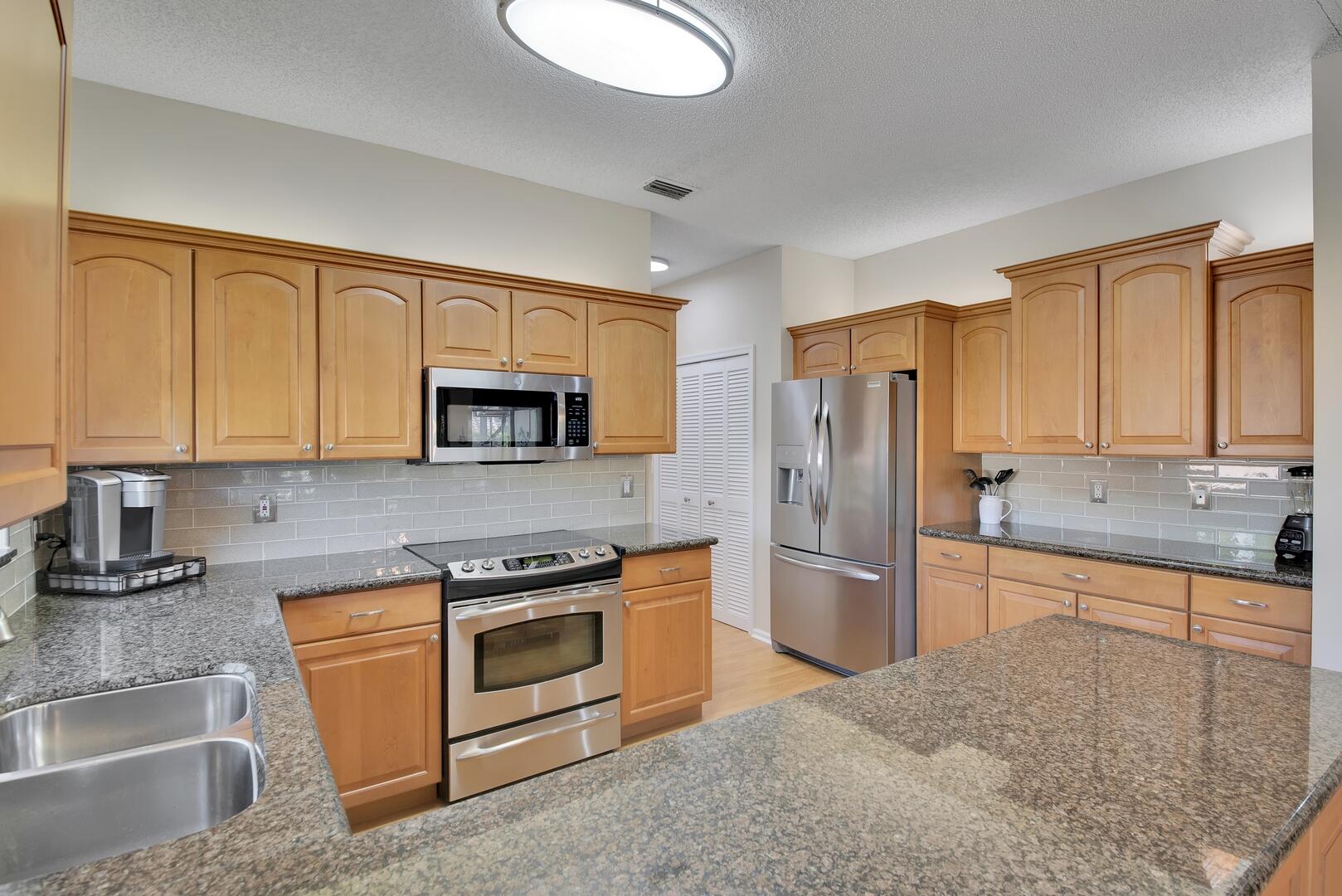 19261 Cherry Hills Terrace Boca Raton, FL 33498 - Photo 13 of 53 a kitchen with stainless steel appliances granite countertop a refrigerator stove and sink