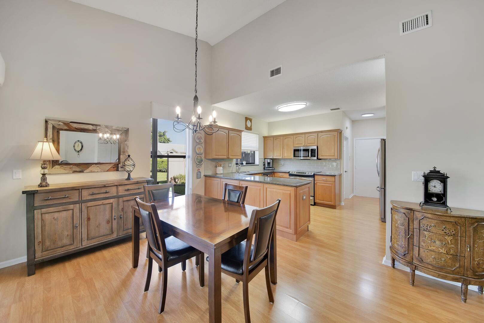 19261 Cherry Hills Terrace Boca Raton, FL 33498 - Photo 15 of 53 a kitchen with stainless steel appliances kitchen island granite countertop a dining table chairs and sink