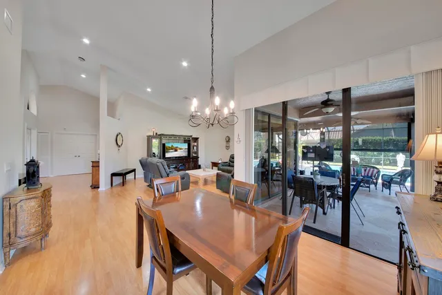 a kitchen with stainless steel appliances kitchen island granite countertop a dining table chairs and sink