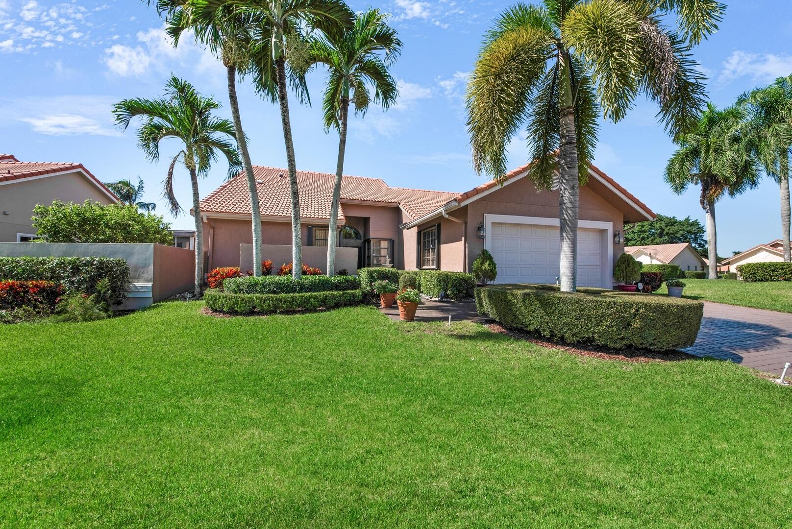 19261 Cherry Hills Terrace Boca Raton, FL 33498 - Photo 39 of 53 a front view of a house with a garden and plants